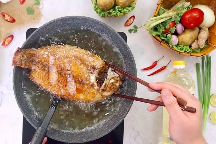 Cá chim chiên vàng mặt đầu tiên trong chảo dầu nóng